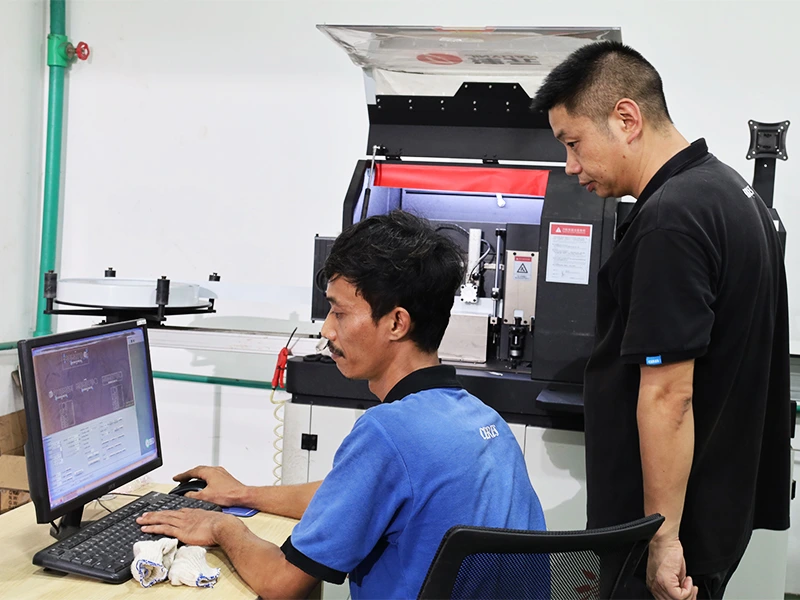 Retail display manufacturing using CNC machine with operator designing and monitoring production process on computer